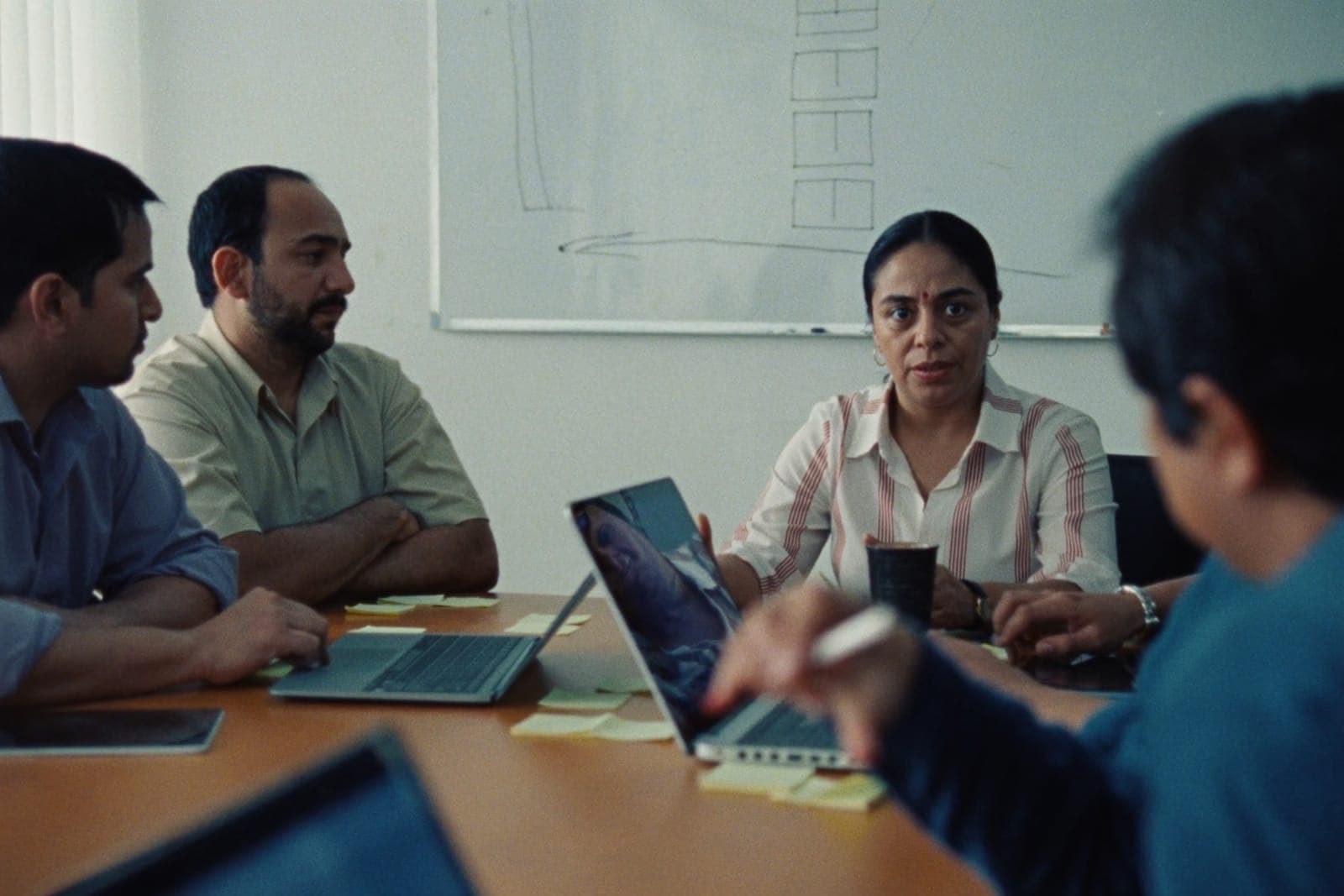 A privacy consultant leading a discussion with a small team around a meeting table